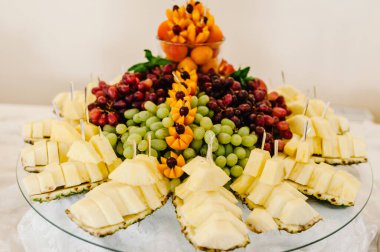 Meyveli tabak. Parti için dekore edilmiş tatlı masası. Taze, egzotik, organik meyveler, açık büfede hafif atıştırmalıklar..