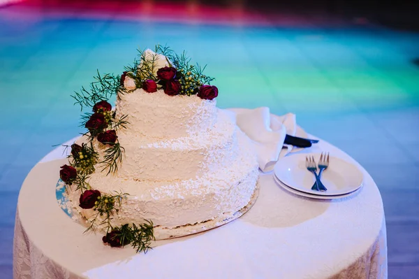 結婚式のケーキ テーブルの上に花で飾られた古典的な層状の白いケーキ — ストック写真