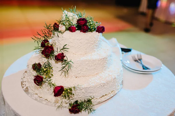 結婚式のケーキ テーブルの上に花で飾られた古典的な層状の白いケーキ — ストック写真