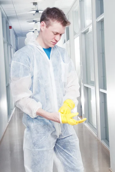 Schoonmaken kantoor in overall, beschermende handschoenen zetten — Stockfoto