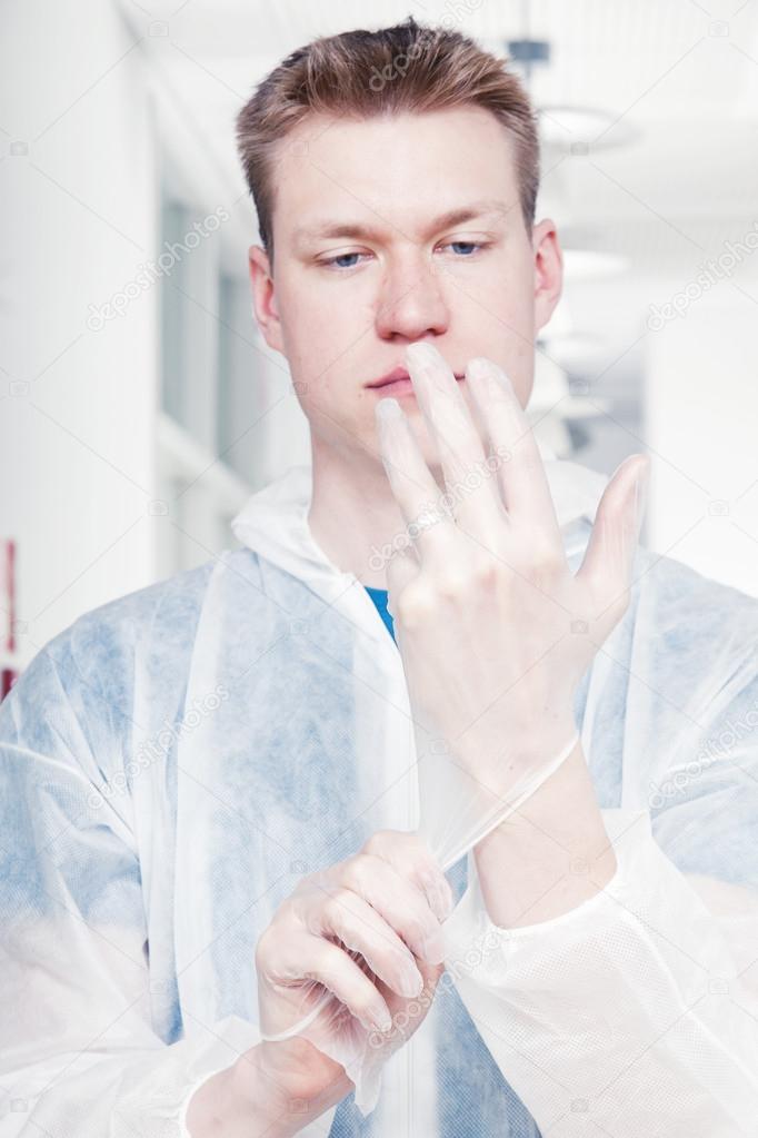Cleaner man putting protective gloves on