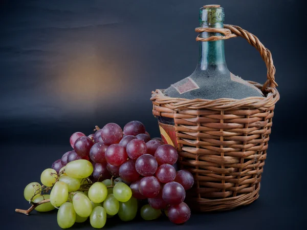 Бутылка красного вина и винограда — стоковое фото