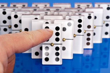 onları itmek bir parmak ile mavi üzerinde Domino.
