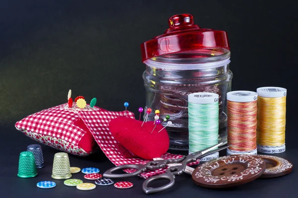 Glass Jar, Neddle Case, Spools, Buttons, Scissors and Thimbles on Black. — Stock Photo, Image