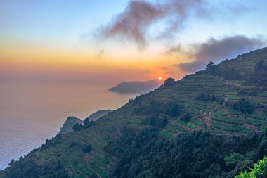Cinque Terre 'de gün batımı Manarola ve Corniglia, İtalya arasında bir yürüyüş patikasında.