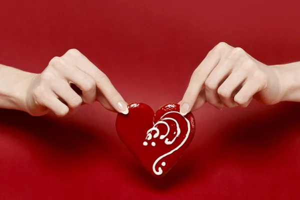 Red heart in beautiful hands isolated on red background — Stock Photo, Image