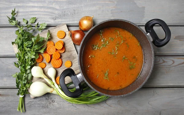 Vue de dessus sur pot de soupe aux tomates et légumes frais sur vieux bois — Photo