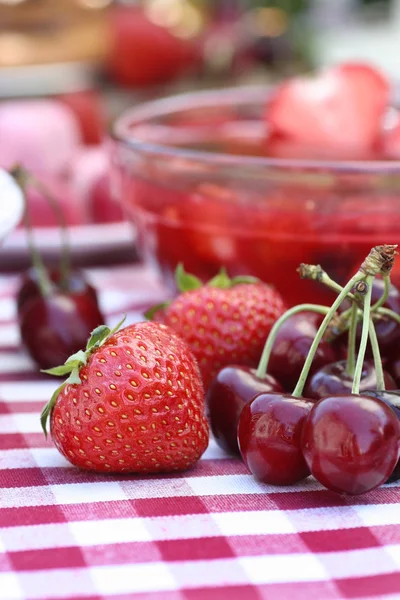 Strawberries and cherries on a table — Stock Photo, Image