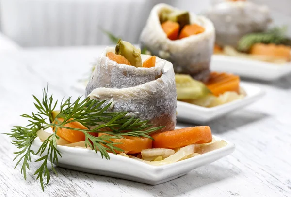 Rouleaux de hareng marinés aux légumes sur table en bois — Photo