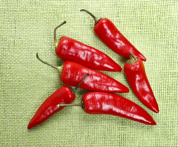 Pimentos de pimenta vermelha na juta verde — Fotografia de Stock