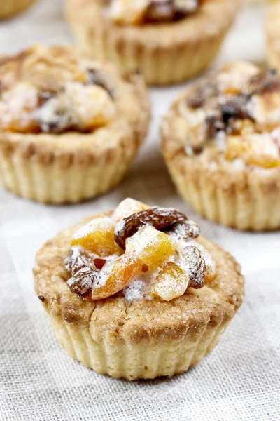 Homemade tarts with dried fruits on checked table cloth — Stock Photo, Image