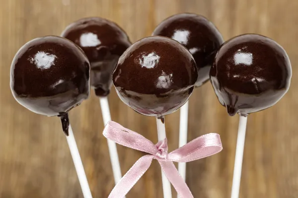 Chokladkaka dyker isolerade på trä bakgrund. — Stockfoto