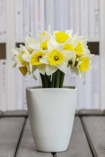 Bouquet di narcisi freschi in vaso di ceramica bianca su legno grigio — Foto Stock