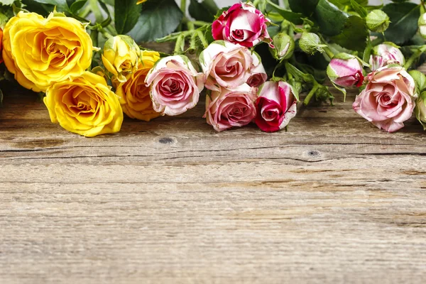 Holzoberfläche mit Kopierraum dekoriert mit bunten Rosen. — Stockfoto