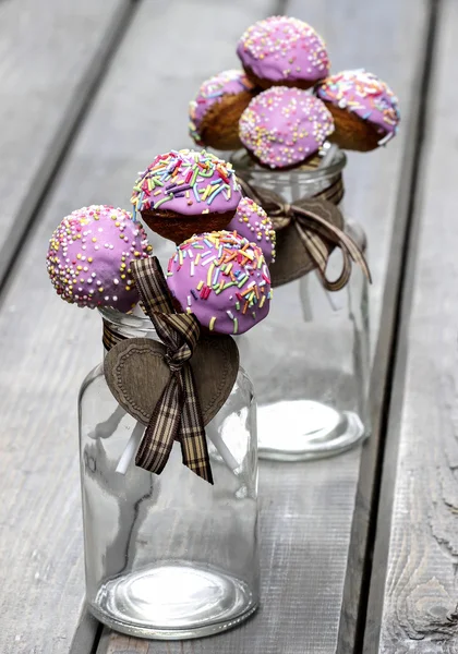 Cake pops dekorerade med strössel på grå träbord — Stockfoto