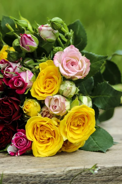 Fantastische boeket kleurrijke rozen op houten dienblad in verse sprin — Stockfoto
