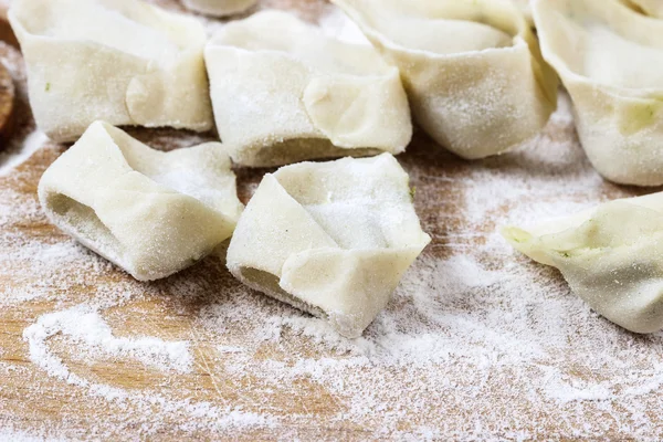 Maken van knoedels, raw gebak op houten bord. — Stockfoto