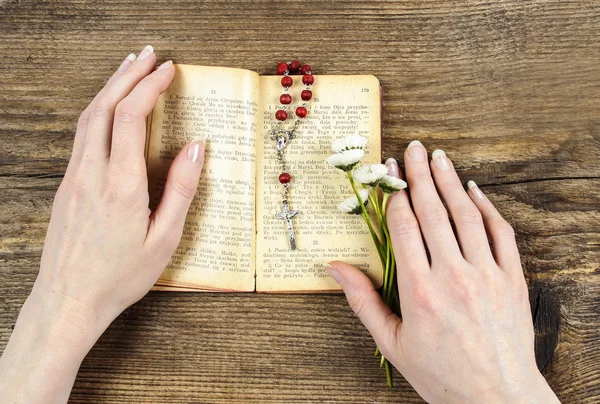 Hands holding the Bible and praying with a rosary — Stock Photo, Image