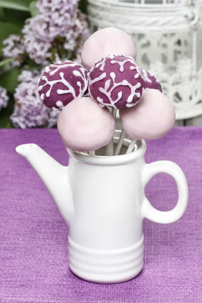 Lila und lila Cake Pops in weißer Keramikkanne, Geburtstagsfeier. — Stockfoto