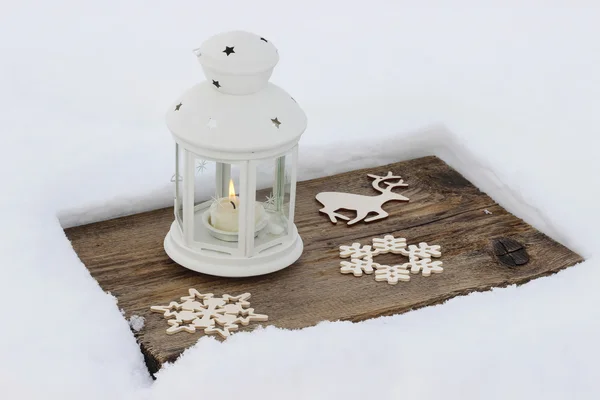 Linterna blanca de pie sobre tabla de madera, sobre nieve — Foto de Stock