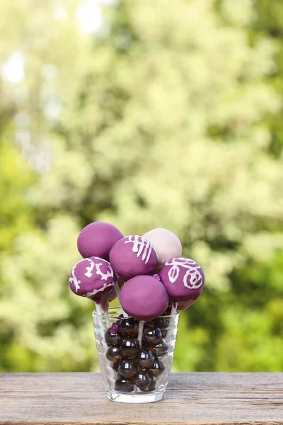 Violett och lila cake pops på rustika träbord i sommar gard — Stockfoto