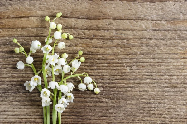 Lilly della valle fiori su sfondo di legno . — Foto Stock