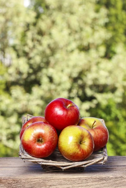 Wicker basket of fresh red ripe apples — Stock Photo, Image