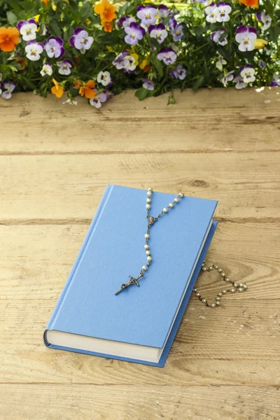 新蓝色圣经和老木表面白色念珠. — 图库照片