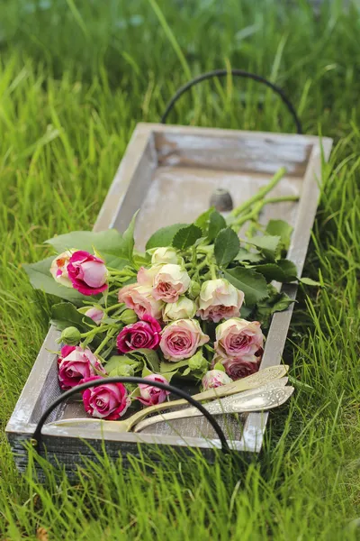 Decoración de la fiesta del jardín. Ramo de rosas rosadas y tres cucharas bonitas —  Fotos de Stock