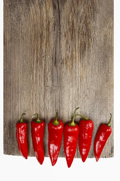 Pimientos rojos picantes en mesa de madera vieja —  Fotos de Stock