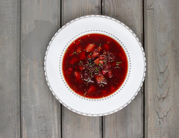 Pohled shora na polévku z červené řepy na starý dřevěný stůl — Stock fotografie
