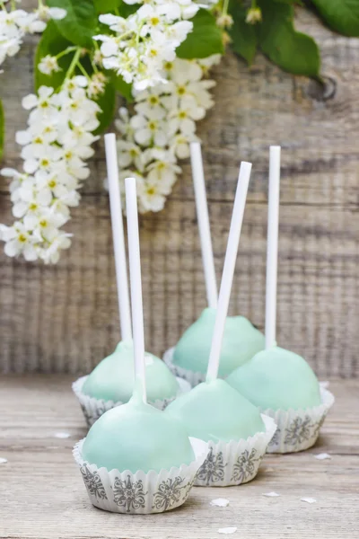 Groene pastel taart POP's op houten tafel. — Stockfoto