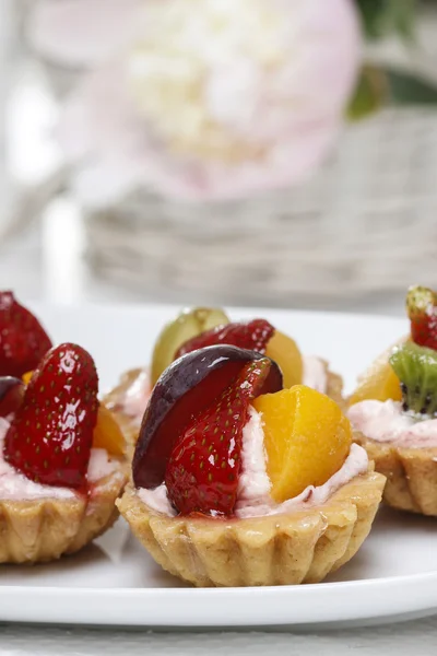 Las magdalenas de colores - el postre de fiesta. Configuración de mesa blanca . — Foto de Stock