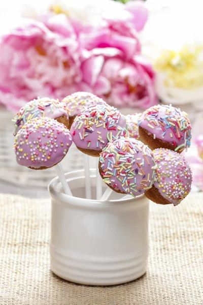 Pastell Cake Pops auf rustikalem Holztisch. atemberaubende Pfingstrosenblüten — Stockfoto