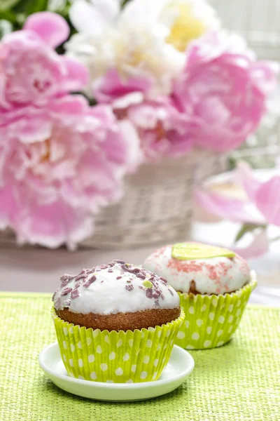Cupcake su tavolo rustico in legno. Splendidi fiori di peonia — Foto Stock