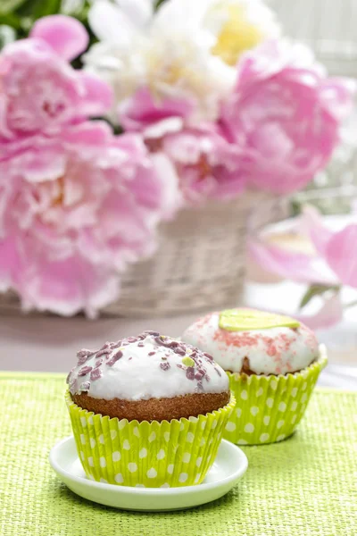 Cakejes op rustieke houten tafel. prachtige peony bloemen — Stockfoto