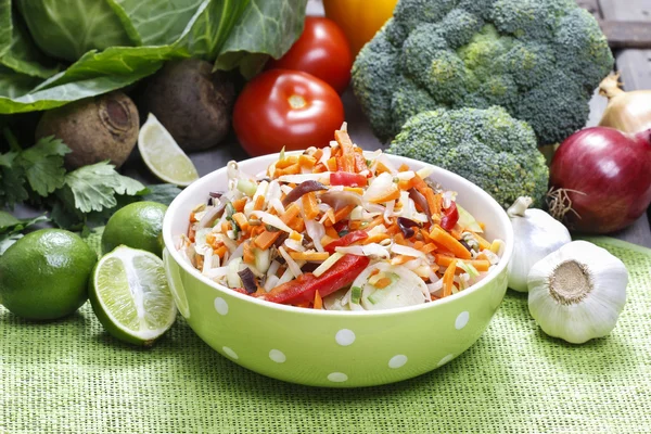 Ensalada de verduras frescas en un bol verde punteado . — Foto de Stock