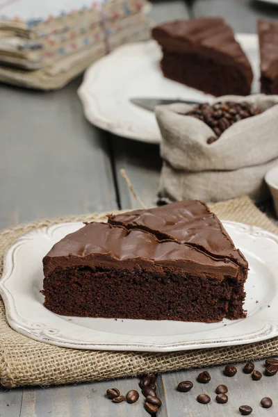 Schokoladenkuchen auf weißem Teller, auf hessisch. Kaffeebohnen — Stockfoto