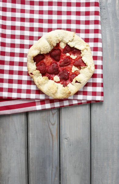 Strawberry tart on checked red and white table cloth on grey woo — Stock Photo, Image