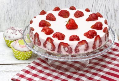 Çilekli pasta üzerinde kırmızı ve beyaz masa örtüsü