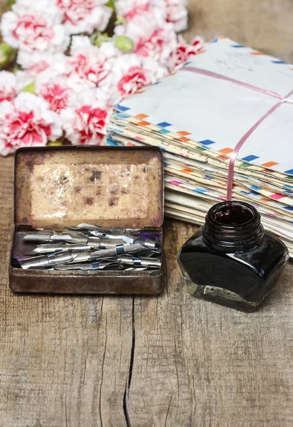 Package of old letters and pink carnation flowers isolated — Stock Photo, Image