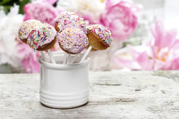 Bolo de pastel aparece na mesa de madeira rústica. Flores peônias deslumbrantes — Fotografia de Stock