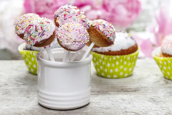 Pastel bolo pops e cupcakes em mesa de madeira rústica — Fotografia de Stock