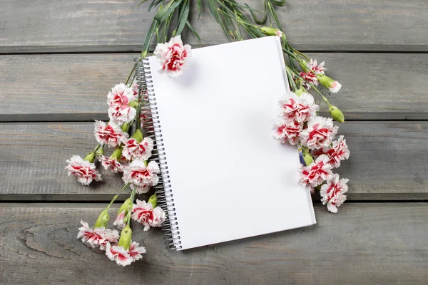 Widok z góry pusty arkusz Notebook wśród kwiatów Goździk różowy — Zdjęcie stockowe