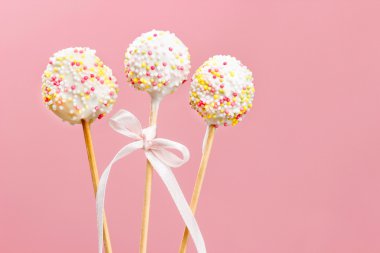 pembe bir arka plan üzerinde sprinkles ile süslü pasta pops