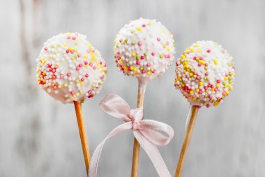 pembe bir arka plan üzerinde sprinkles ile süslü pasta pops