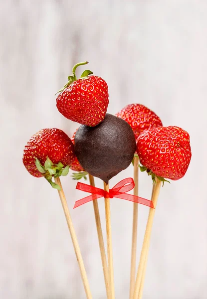 Chocoladetaart knalt en aardbeien op stokken — Stockfoto