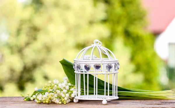 Lilly of the valley flowers and decorative vintage birdcage — Stock Photo, Image