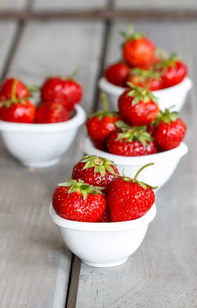 Frische reife Erdbeeren in weißen Keramikschalen — Stockfoto