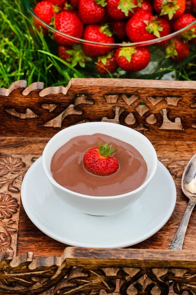 Сливочный шоколадный пудинг на деревянном подносе в саду — стоковое фото